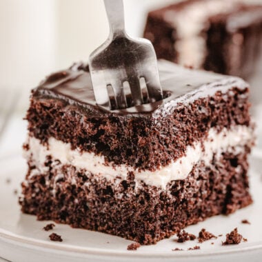 taking a forkful of chocolate cream cake