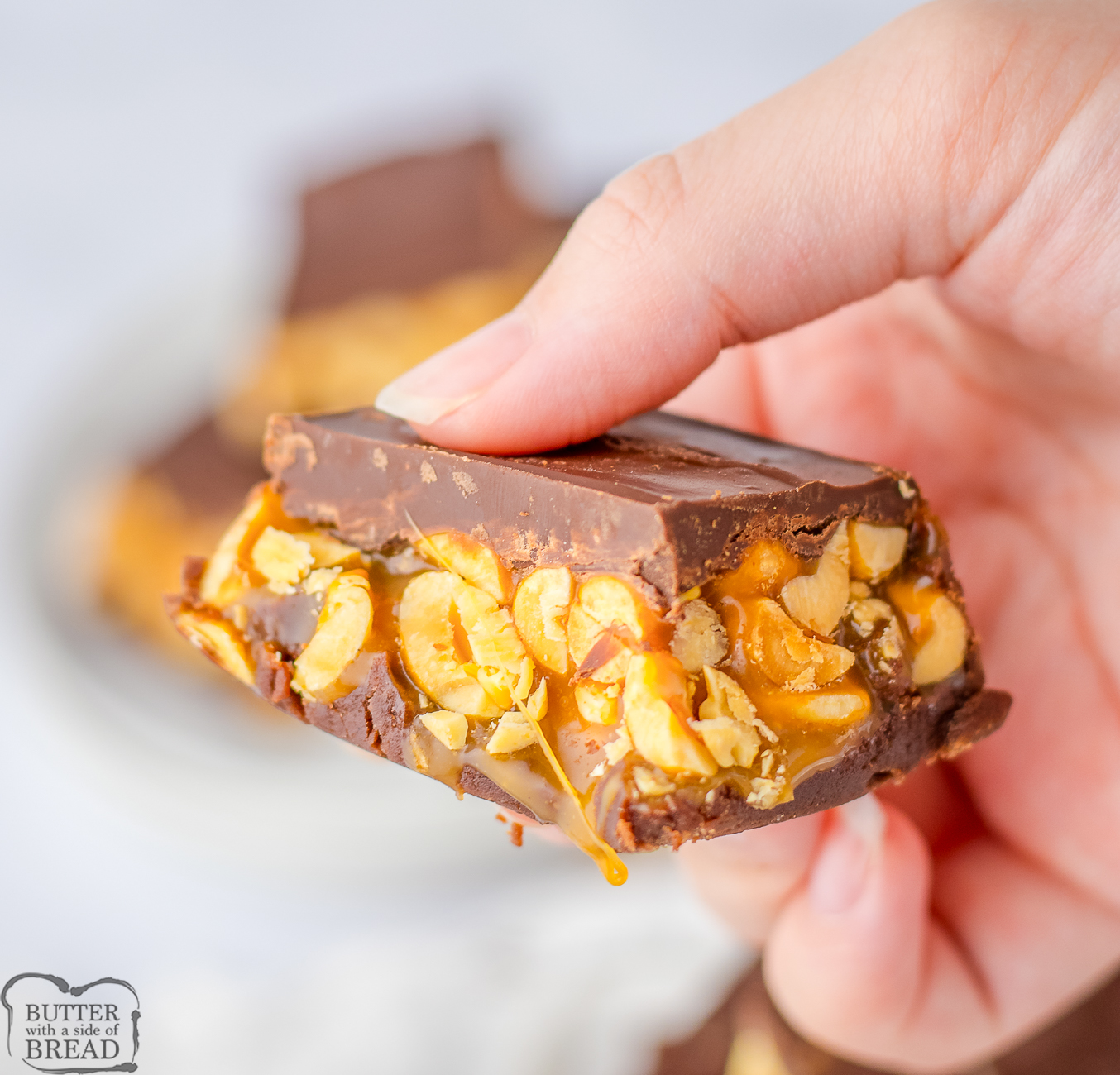 holding a piece of chocolate caramel peanut fudge