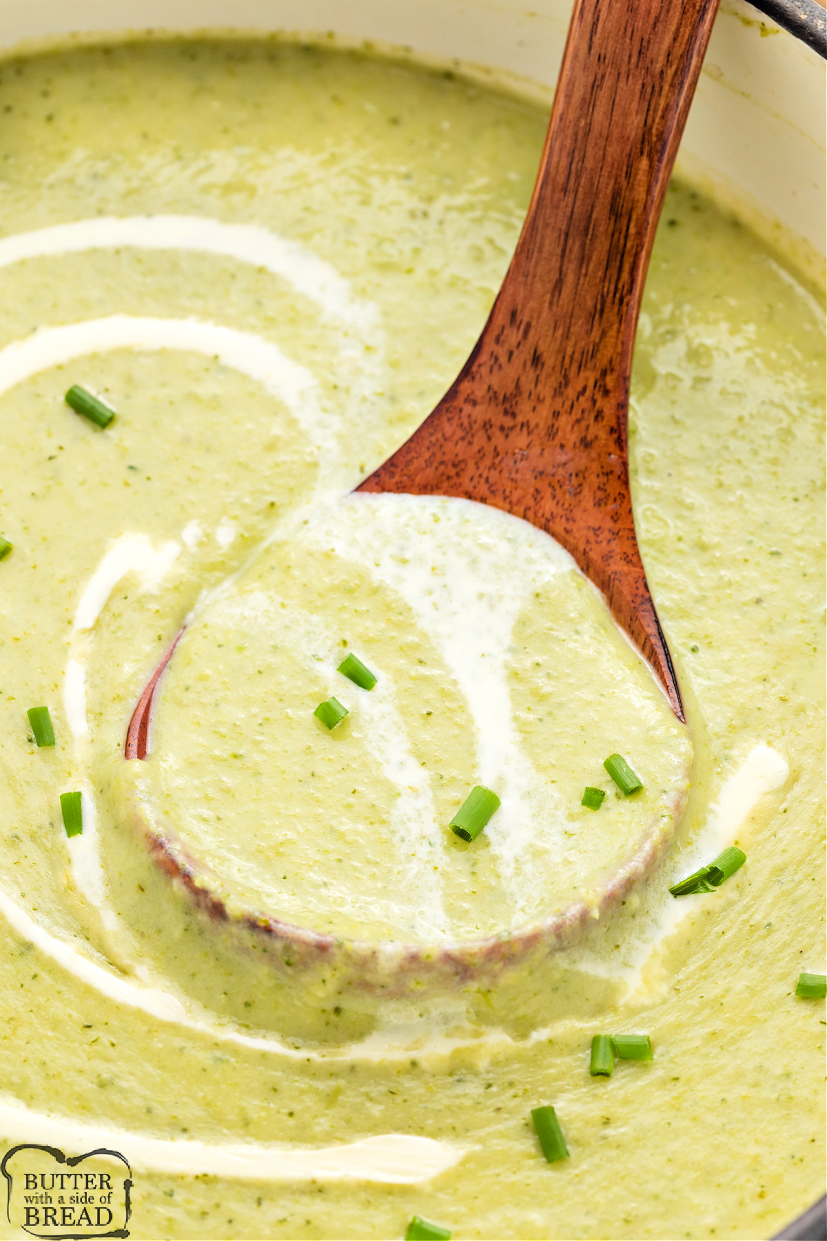 Close up of blended broccoli soup with swirls of cream on top.