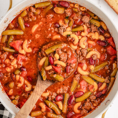 Italian beef soup in a white pot with a spoon