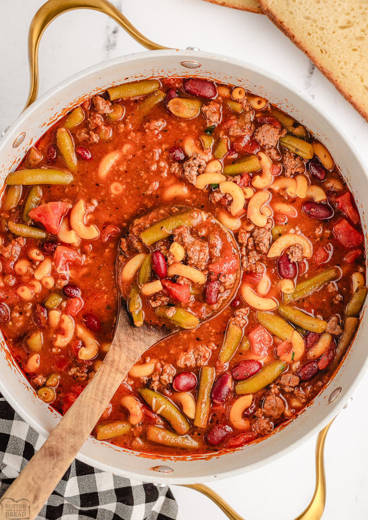 Italian beef soup in a white pot with a spoon