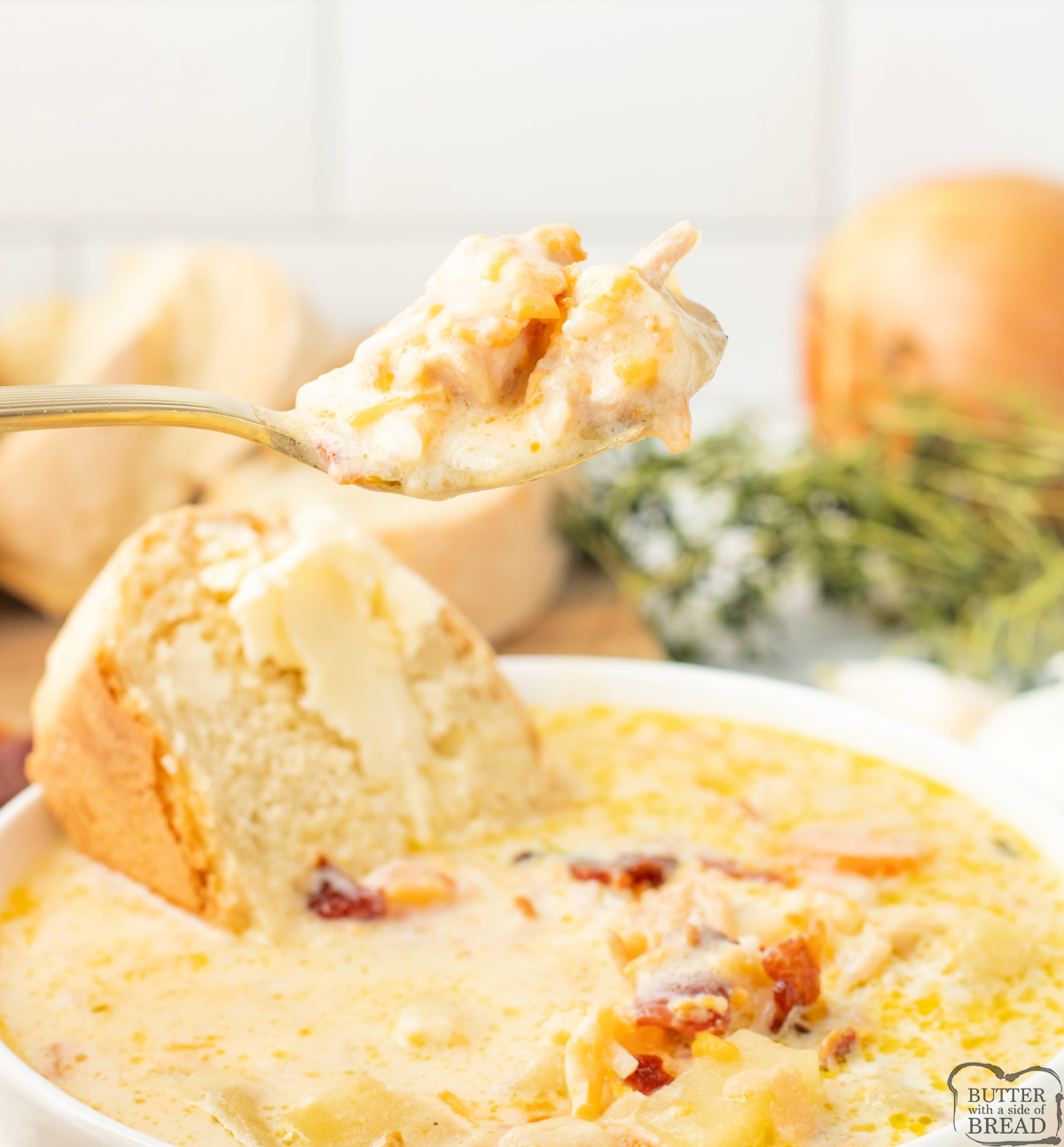 Spoonful of chicken potato soup showing potatoes, chicken, and bacon.