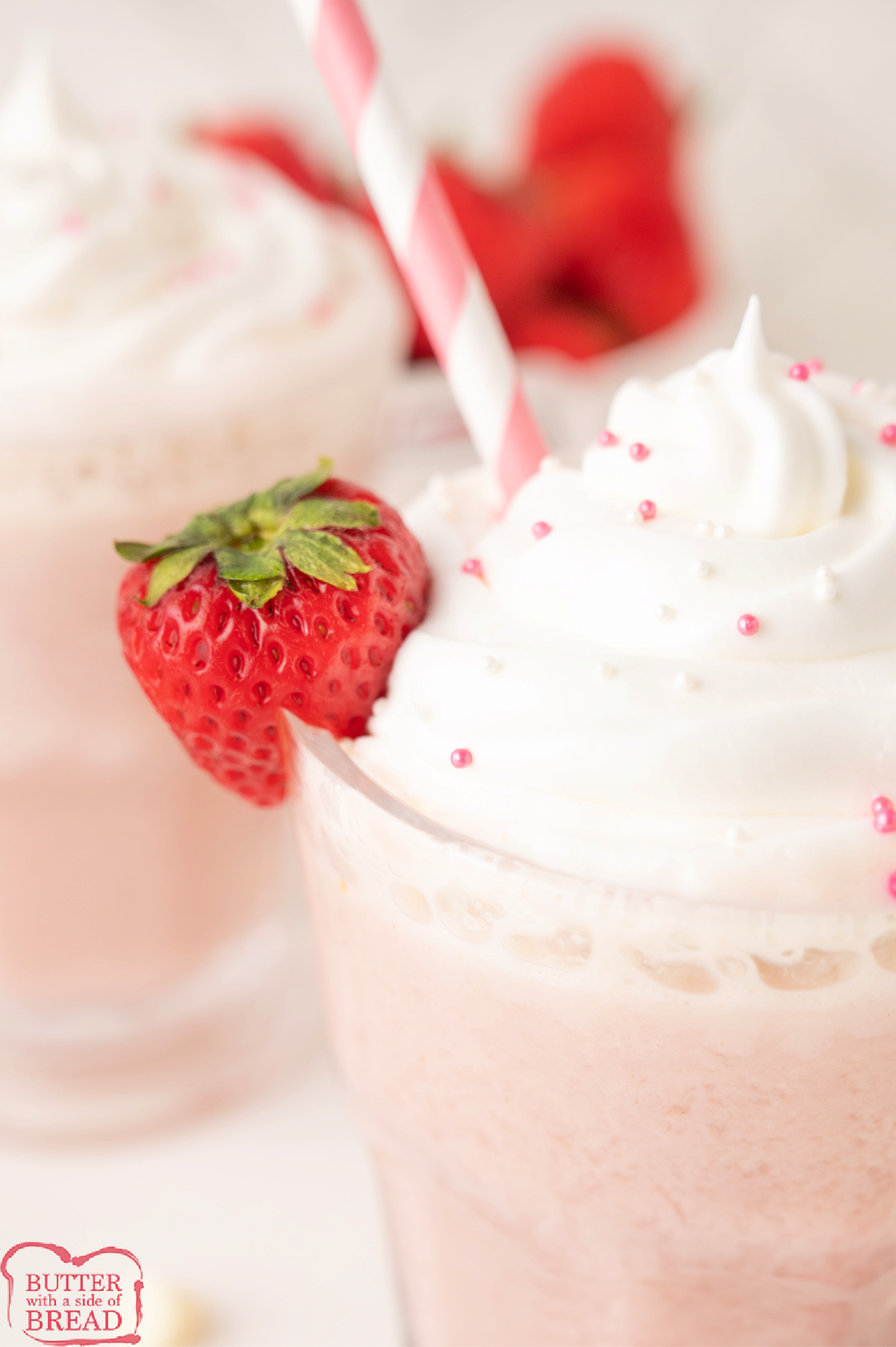 Creamy pink strawberry hot chocolate with whipped cream and sprinkles.