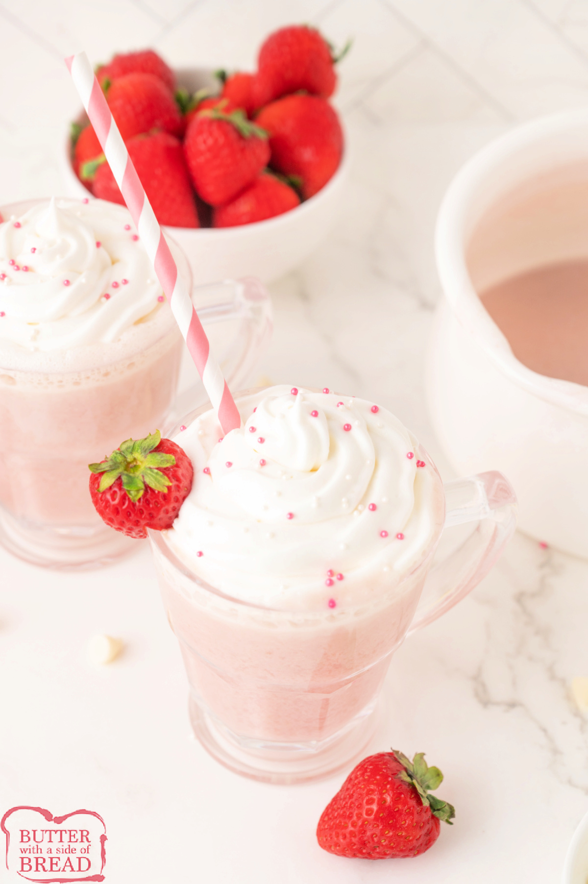 Strawberry hot chocolate with whipped cream and sprinkles on top.