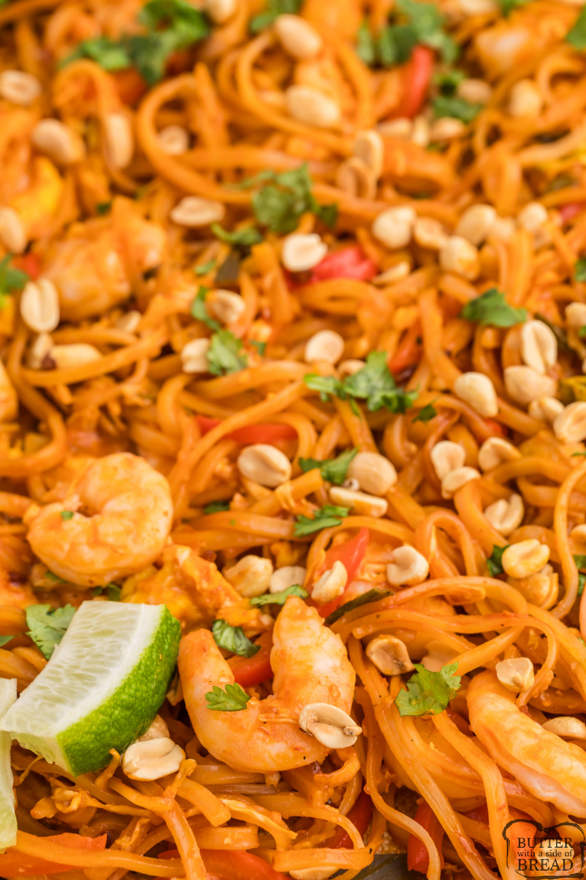Shrimp pad thai baked on a sheet pan with peanuts and lime.