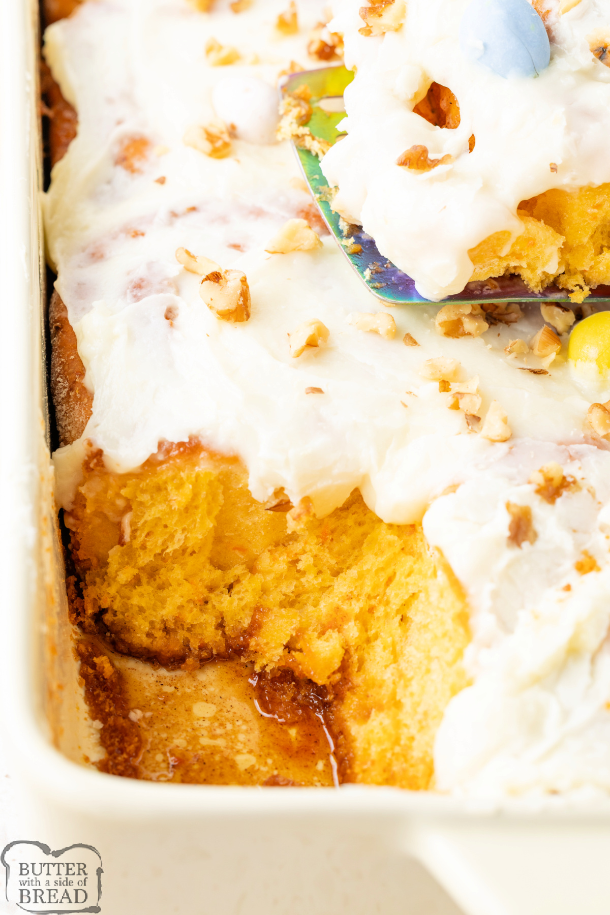 Freshly baked carrot cake cinnamon rolls topped with walnuts and candy eggs.