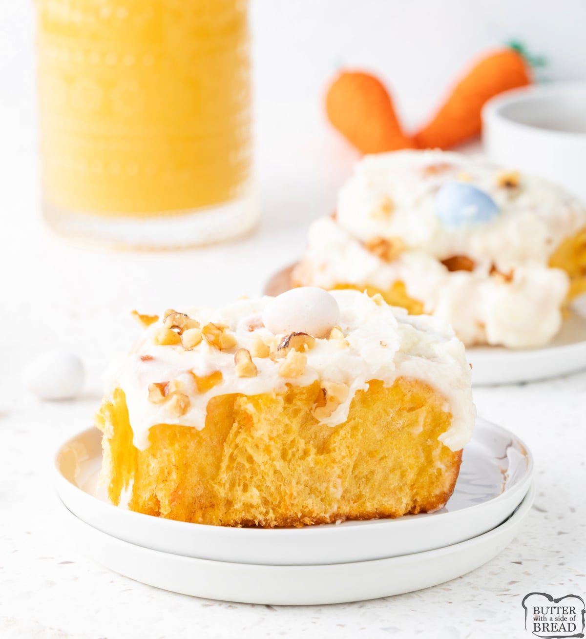 Freshly baked carrot cake cinnamon rolls topped with walnuts and candy eggs.