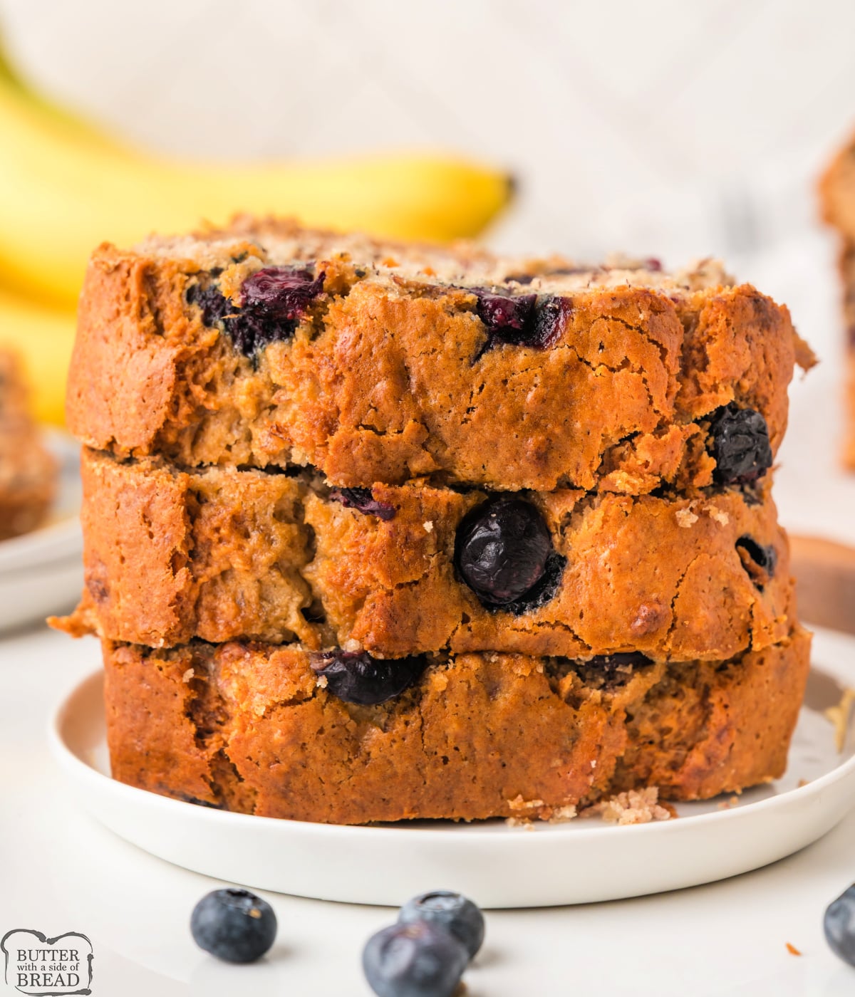 Slices of soft blueberry banana bread served on a plate.
