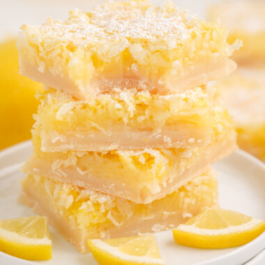 stack of coconut lemon bars on a white plate