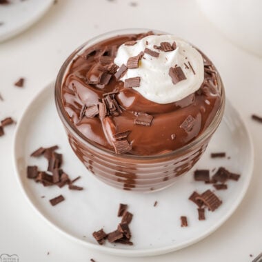 bowl of homemade chocolate pudding with chipped cream and chocolate shavings