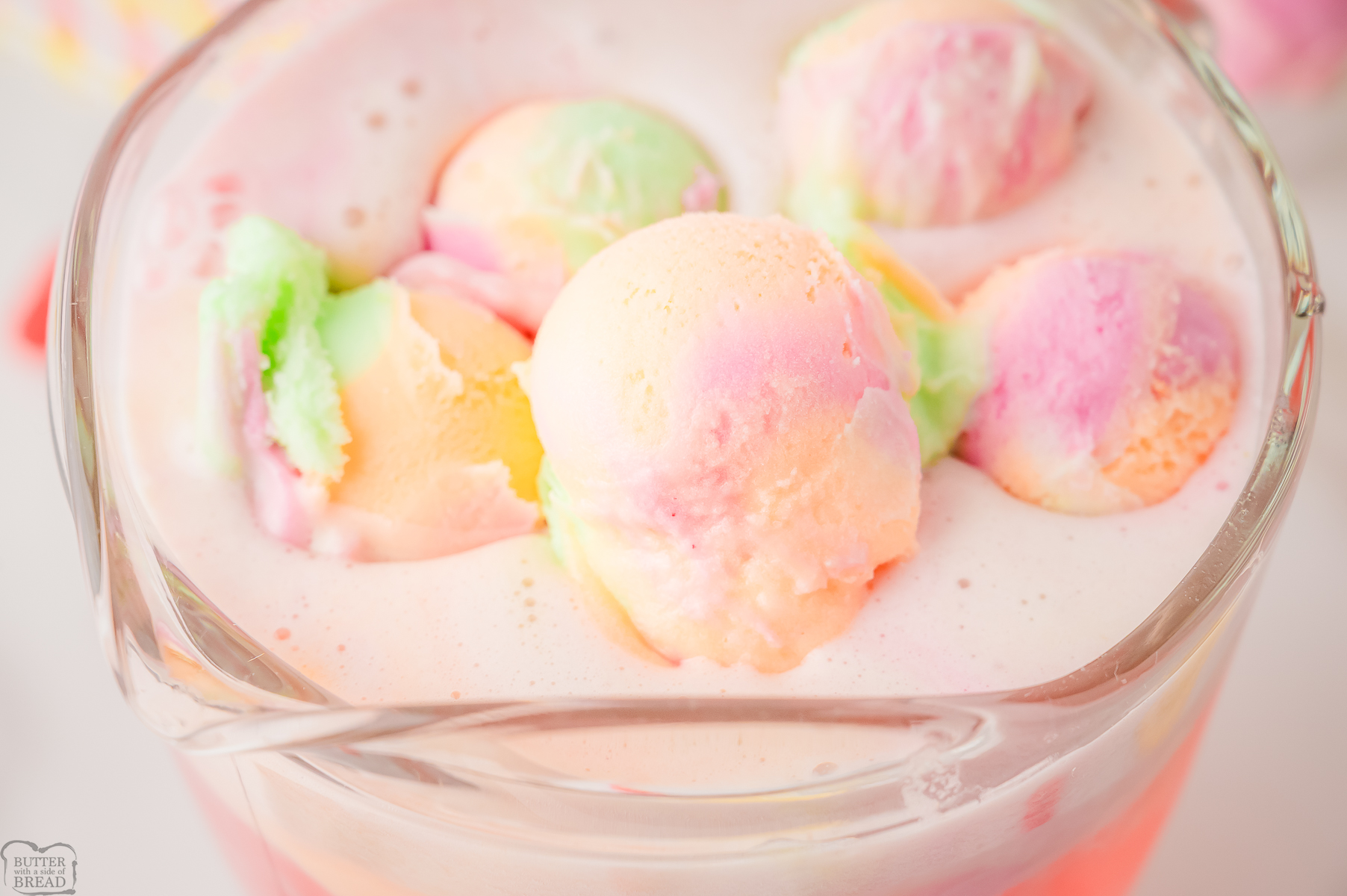 Easy Rainbow Sherbet Punch in a clear glass pitcher