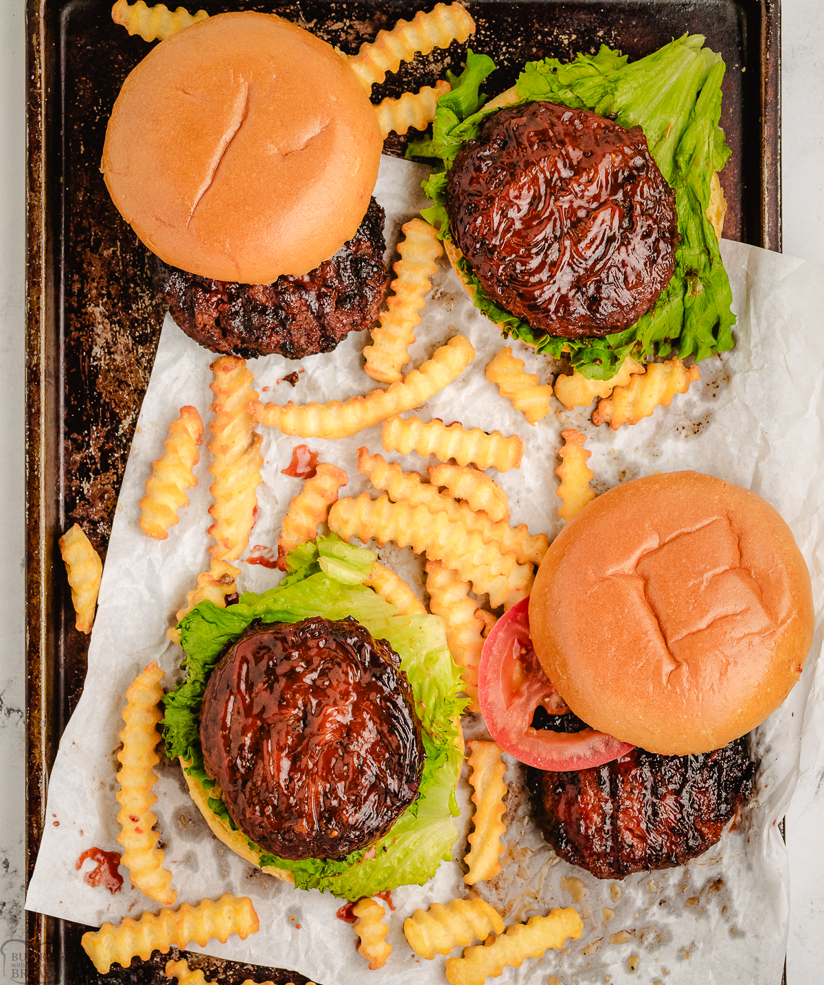 homemade hamburgers on a tray with fries
