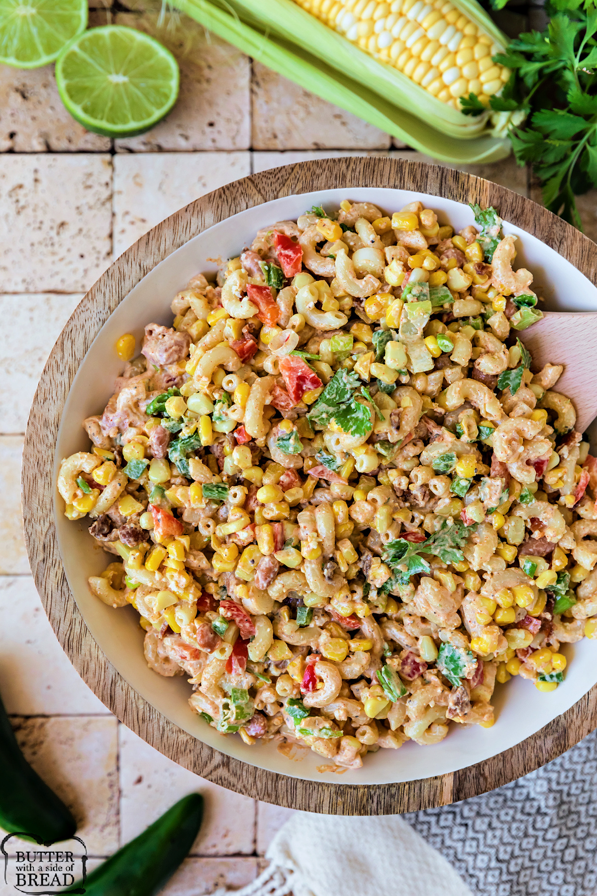 Overhead view of Mexican street corn pasta salad with colorful vegetables, crispy bacon, and creamy dressing.