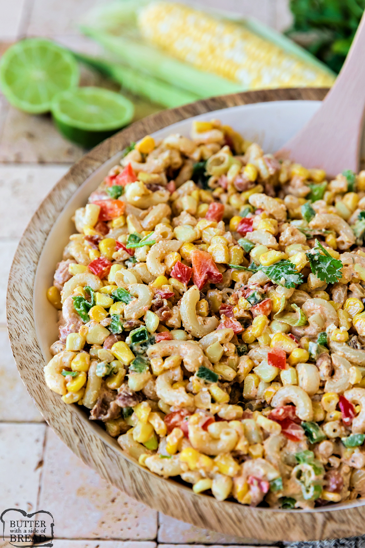 Creamy Mexican street corn pasta salad garnished with cilantro and cotija cheese in a white serving bowl.