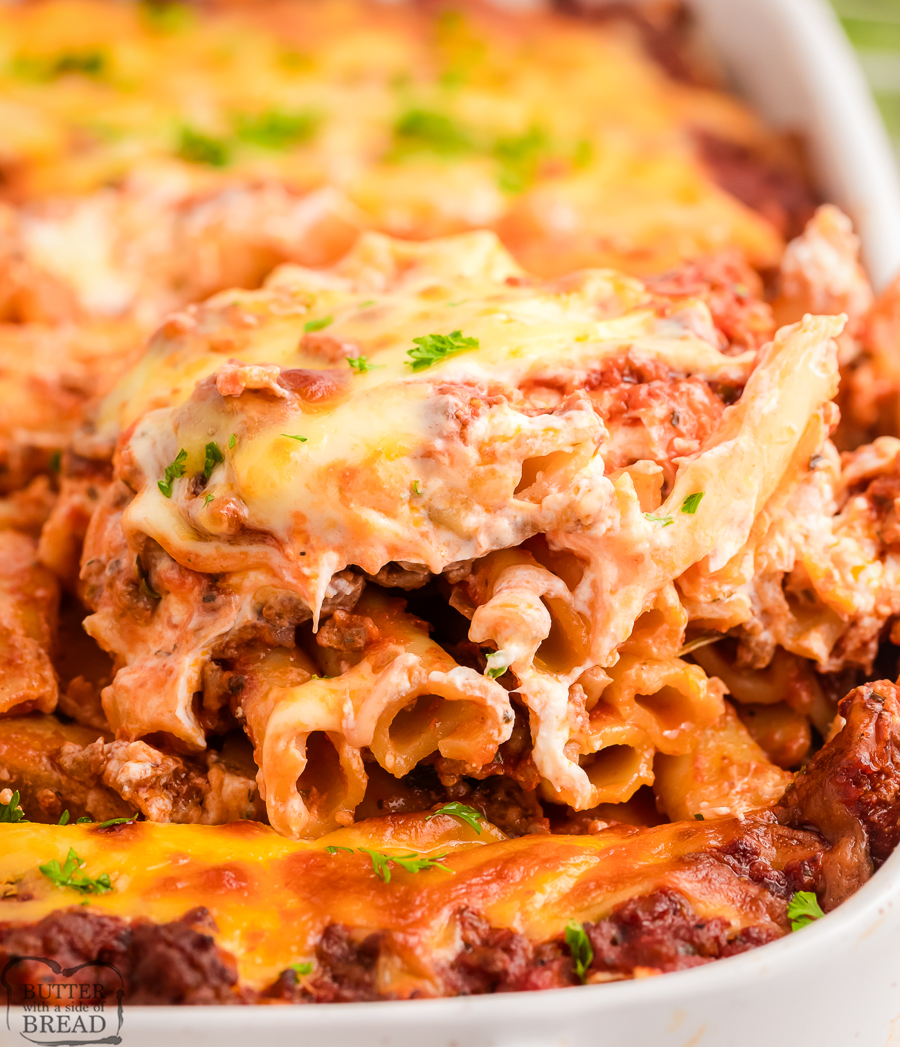 scooping out a serving of baked ziti from a baking dish