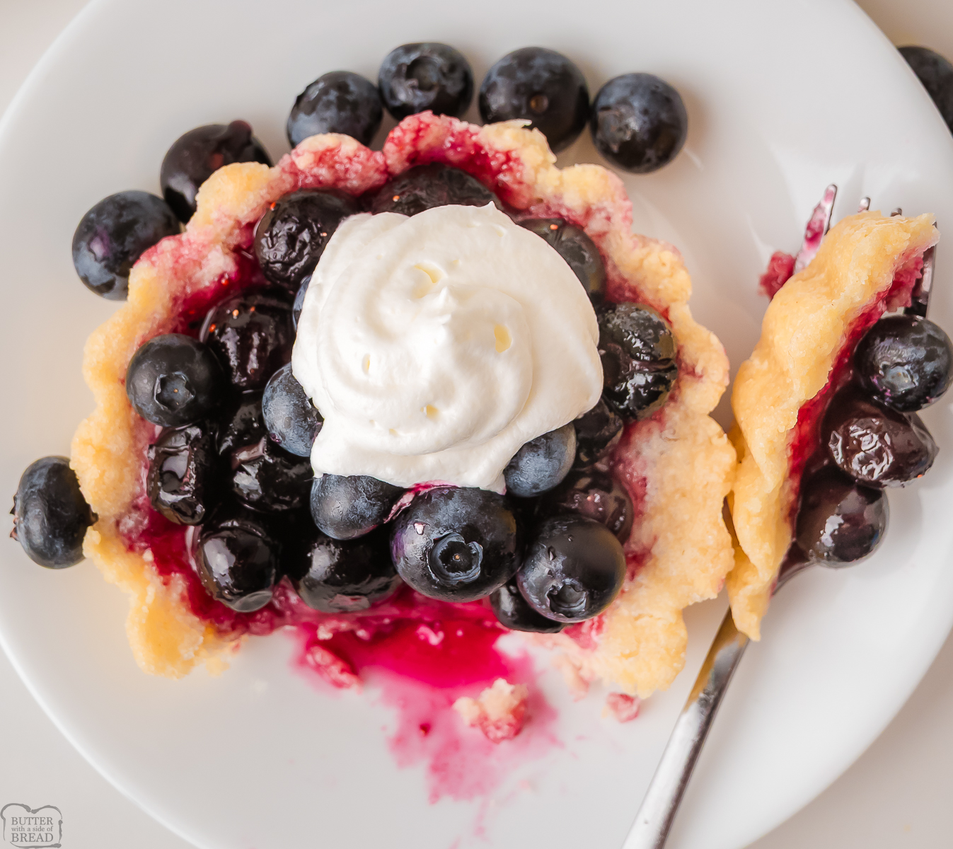 blueberry tart with a forkful taken out