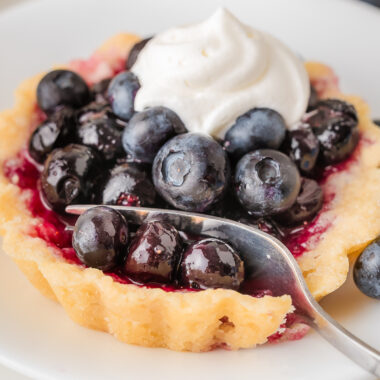 using a fork to take a bite of a Blueberry Tart