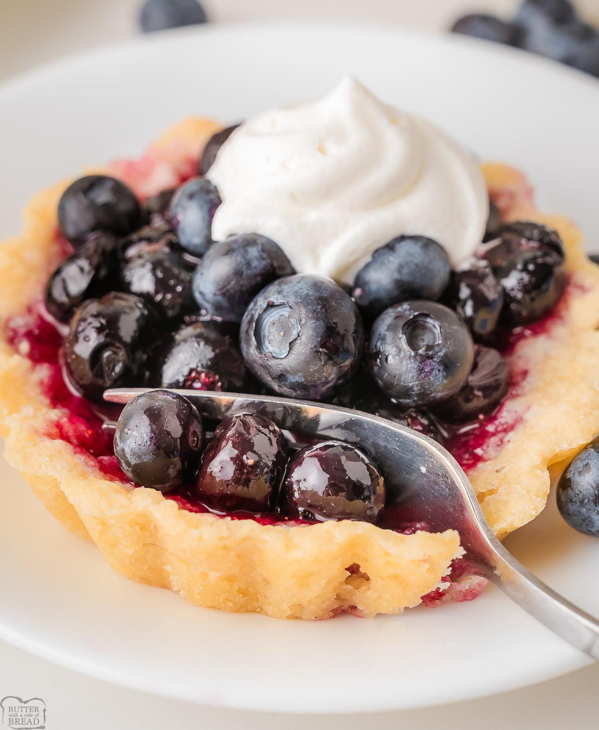 using a fork to take a bite of a Blueberry Tart