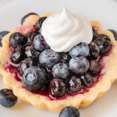 simple blueberry tarts made with both frozen and fresh blueberries, topped with whipped cream