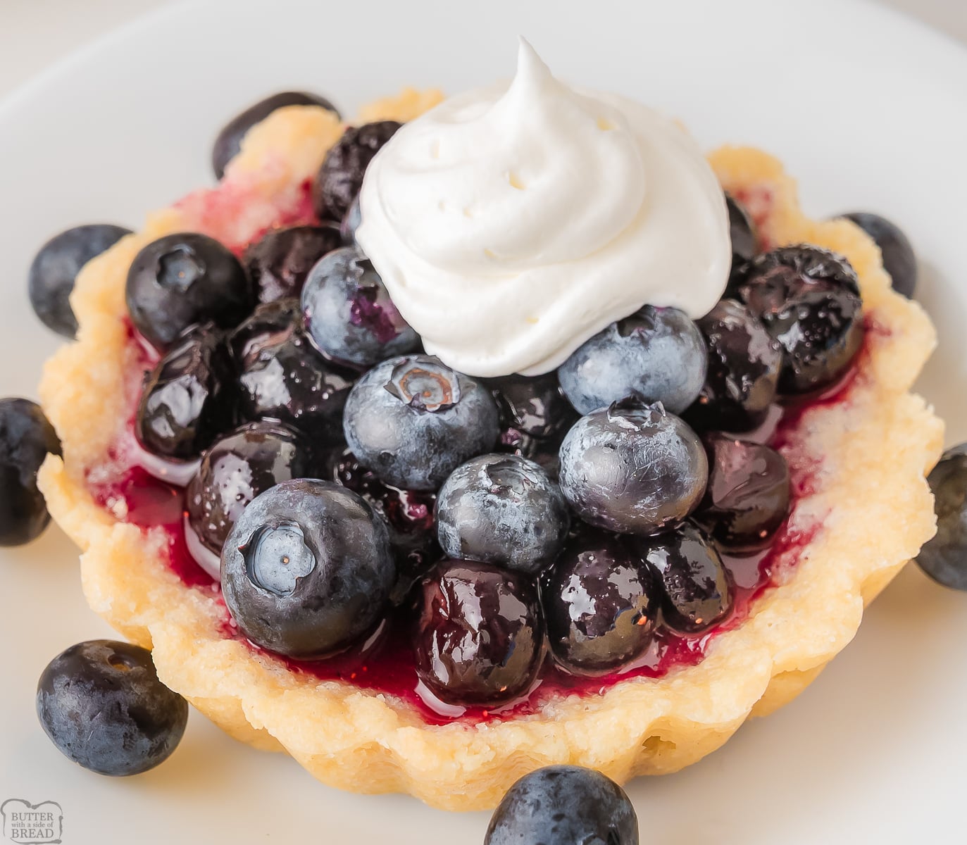 simple blueberry tarts made with both frozen and fresh blueberries, topped with whipped cream