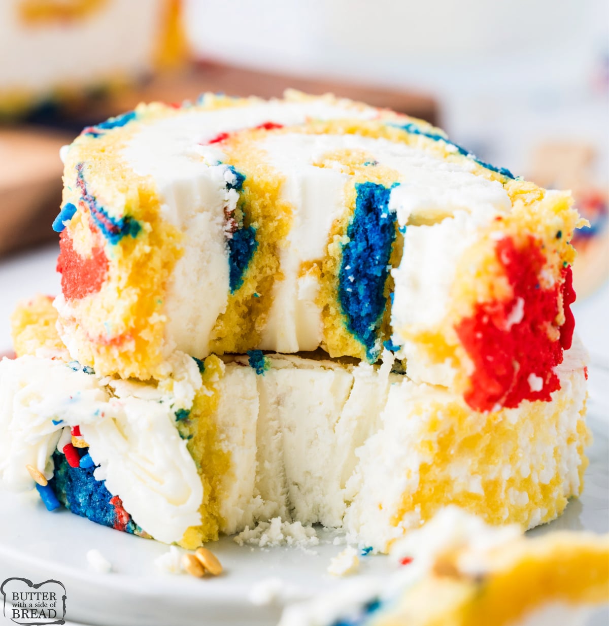 Slices of a patriotic cake roll stacked on a plate. 