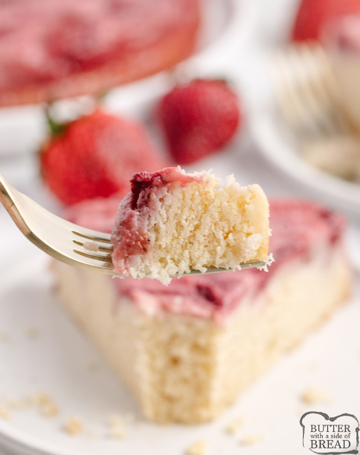 Close-up of strawberry upside-down cake topping with glossy caramelized strawberries and syrupy edges.