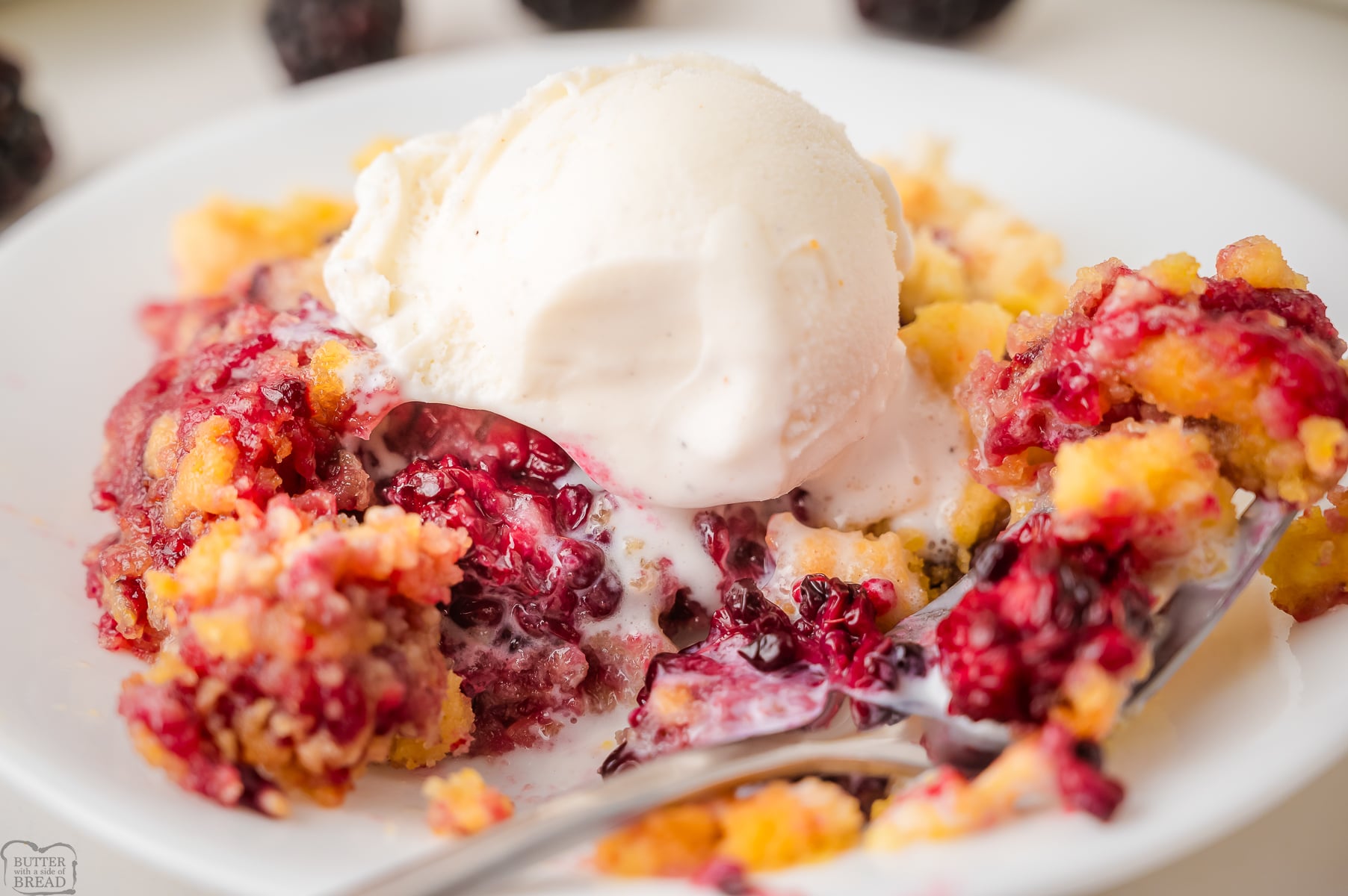 blackberry dump cake in a bowl with ice cream