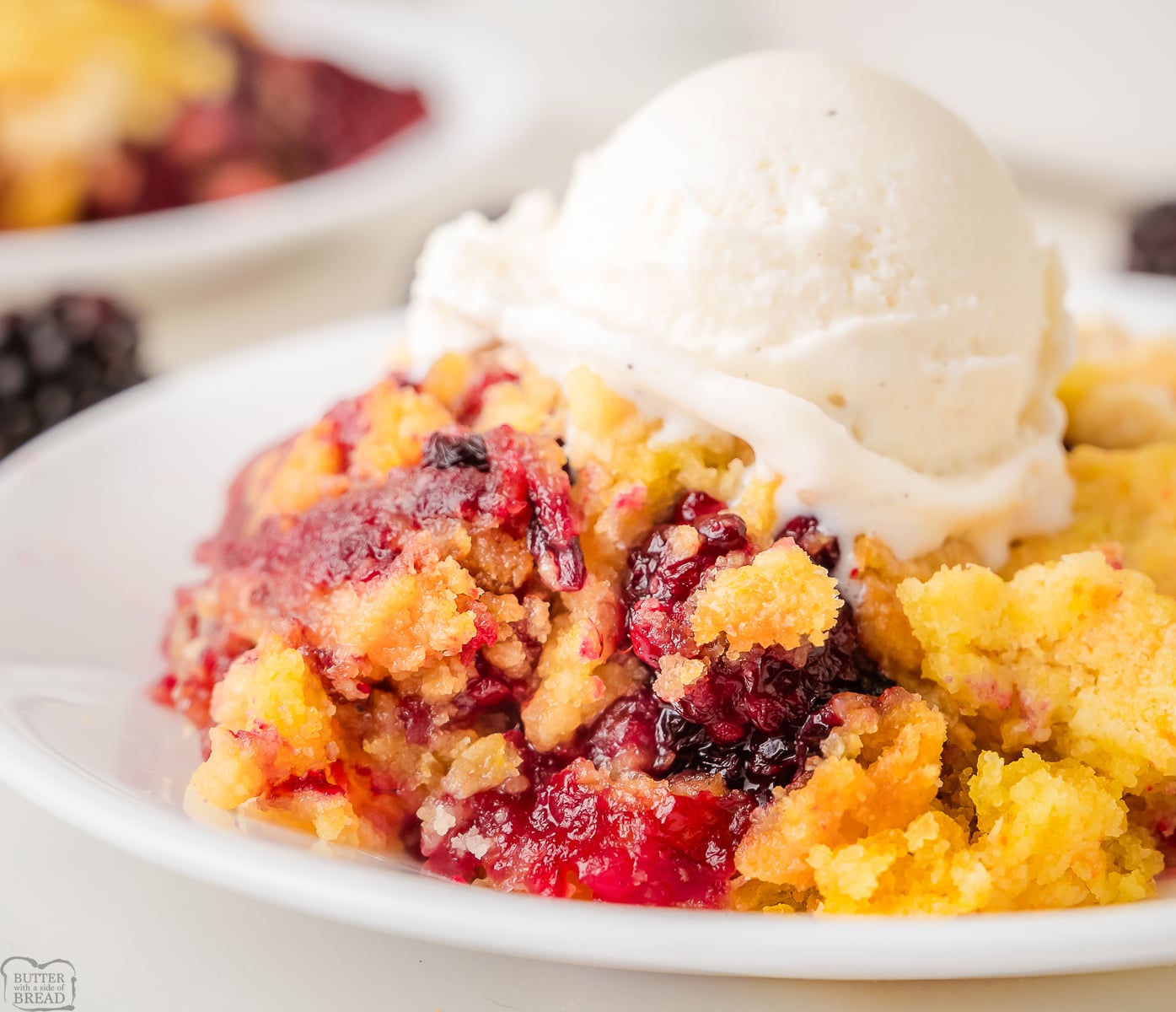 blackberry dump cake topped with vanilla ice cream