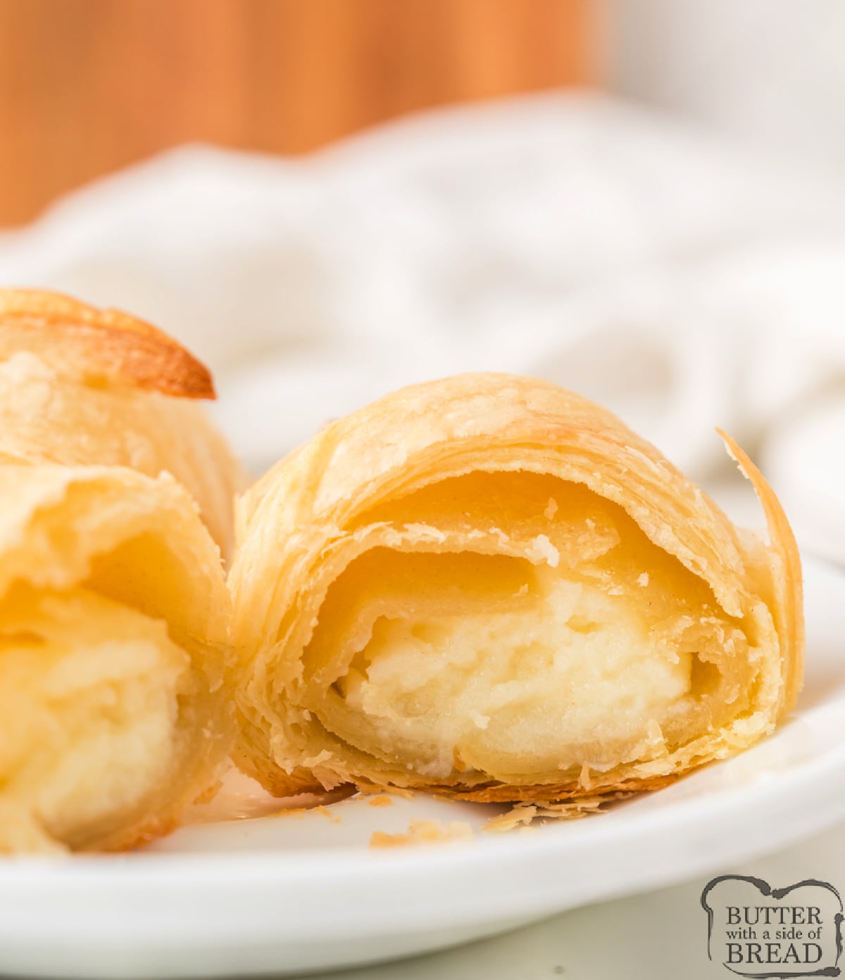 Close up of a cream cheese croissant showing flaky layers and filling.