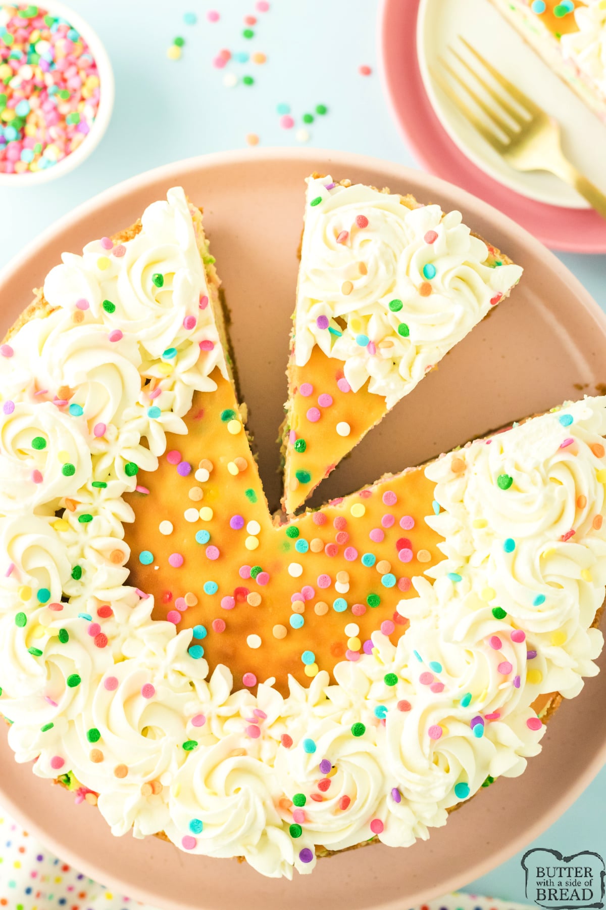 Funfetti cheesecake topped with whipped cream and rainbow sprinkles