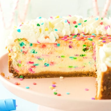 funfetti cheesecake sliced with whipped cream on top