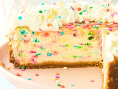 funfetti cheesecake sliced with whipped cream on top