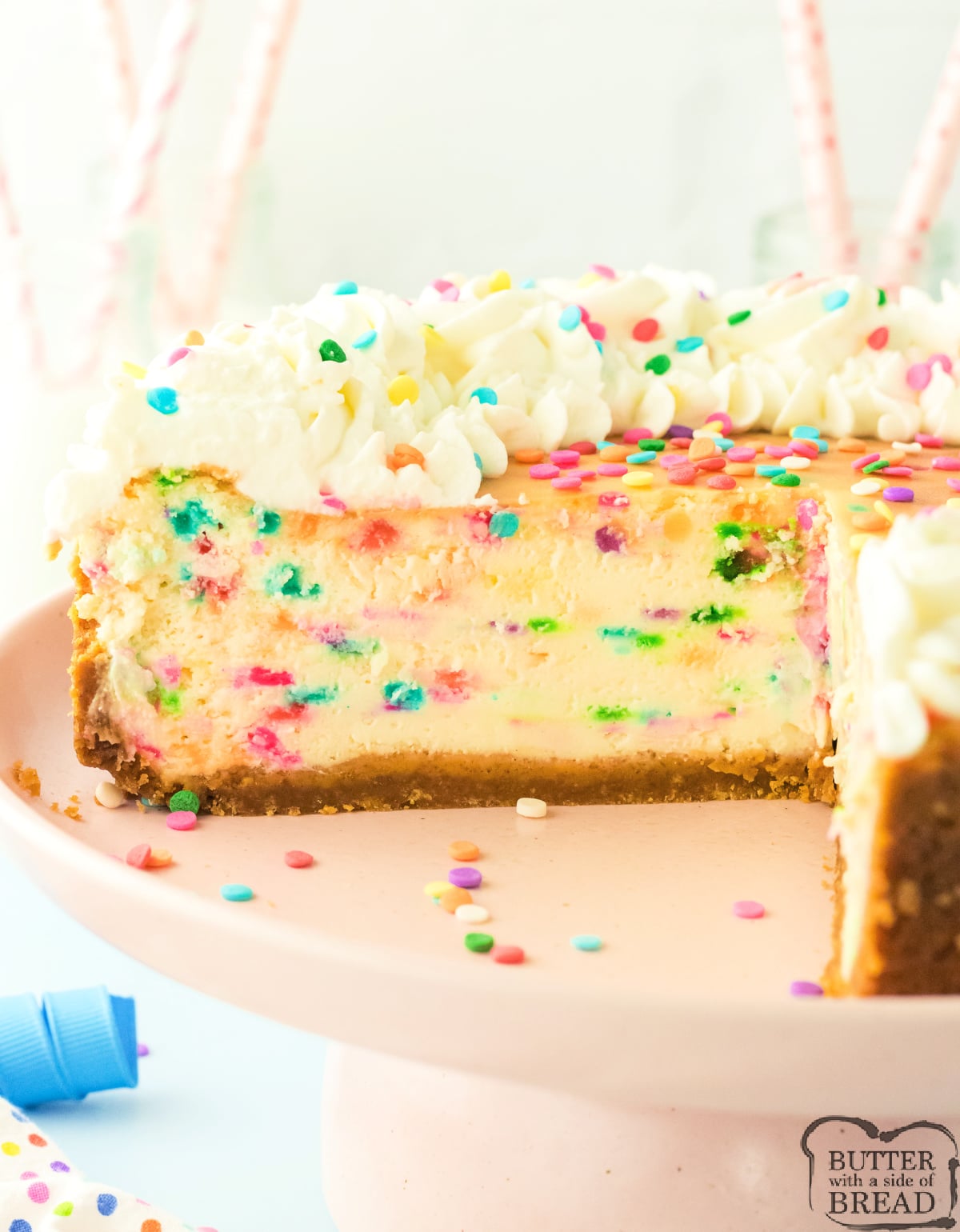 Funfetti cheesecake topped with whipped cream and rainbow sprinkles
