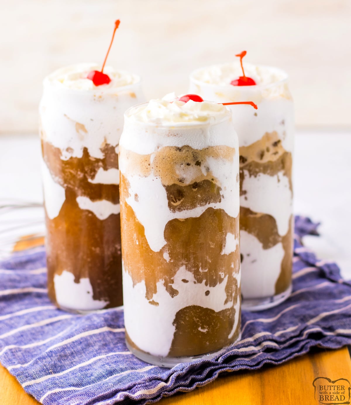 Viral Fluffy Coke recipe in a tall glass with marshmallow fluff, nugget ice, whipped cream and a maraschino cherry