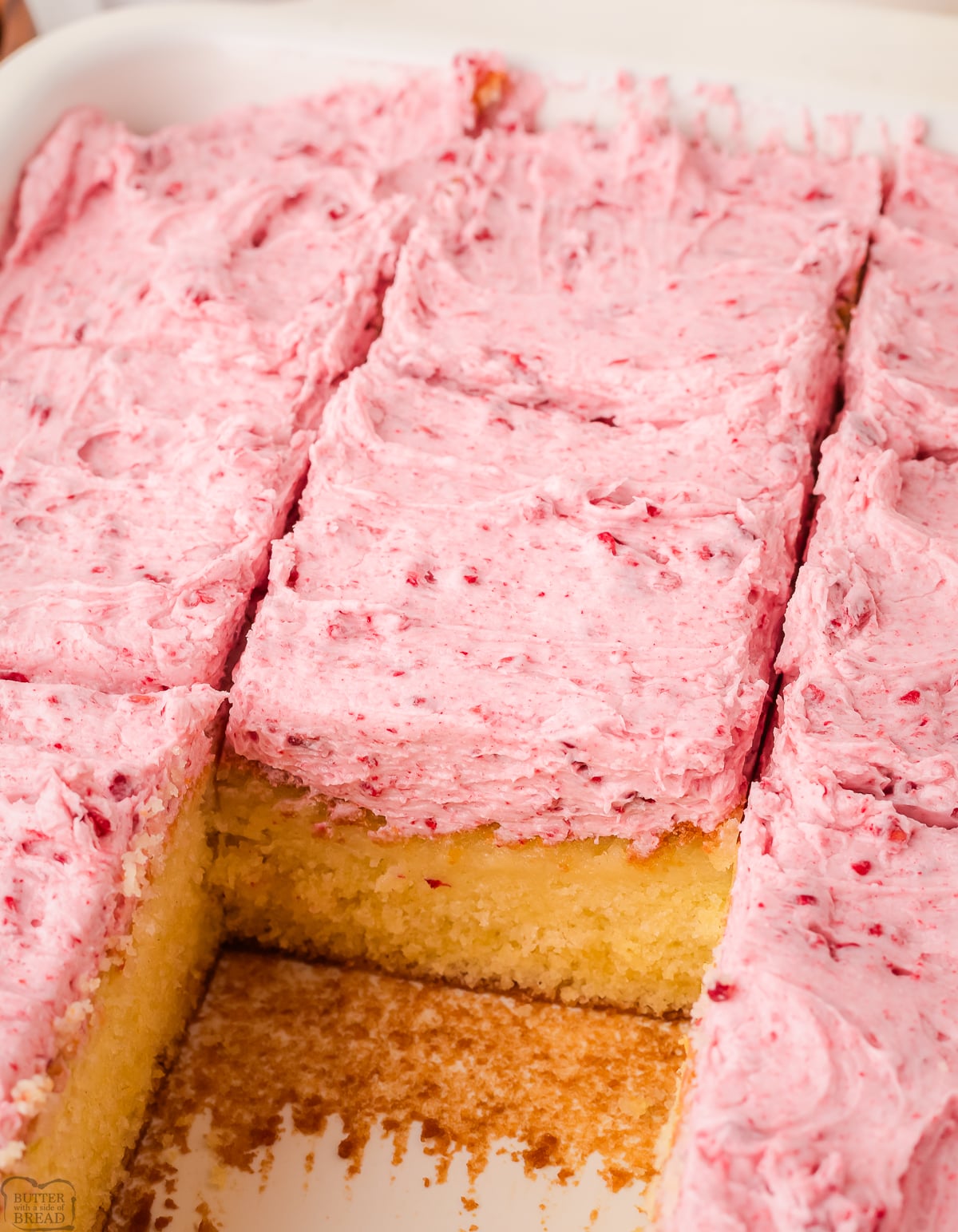 sliced raspberry almond sheet cake in a white baking dish