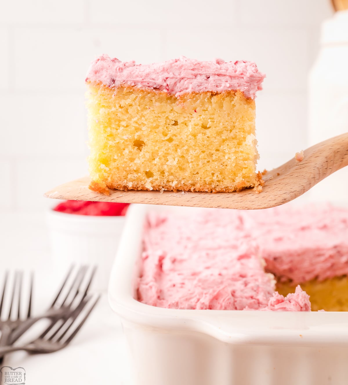 serving up a square of raspberry almond cake